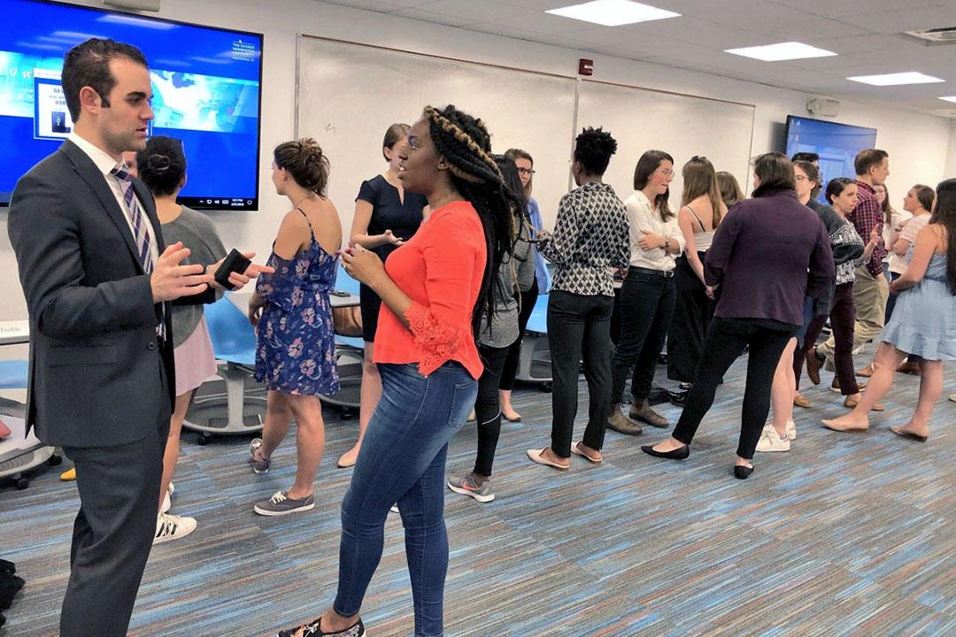 Students and alumni talking together at an alumni networking event